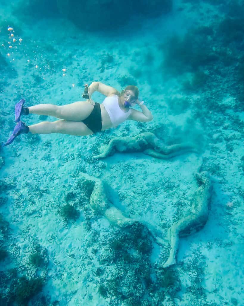 Emulating the stone sculptures while snorkeling near Gili Meno
