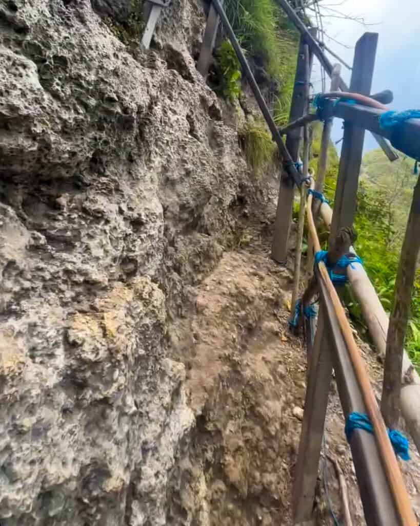 Wooden railing along the KelingKing Beach hike in Nusa Penida protects hikers while climbing up and down the narrow path