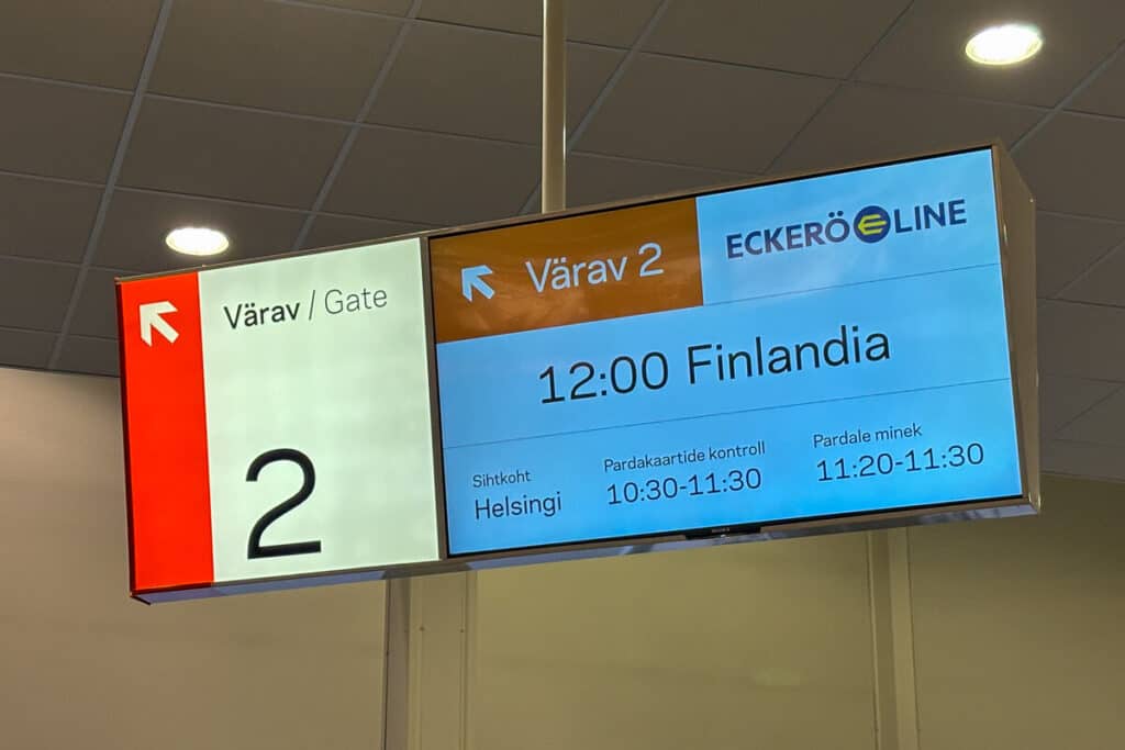 Departure gate sign at Tallinn terminal showing Eckerö Line’s 12:00 ferry to Helsinki aboard the MS Finlandia. Boarding and check-in times are listed in Estonian, with Gate 2 clearly marked.