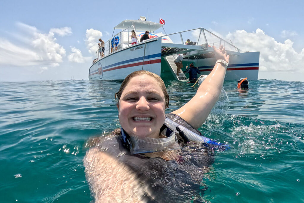 Snorkeler in the water beside the Fury Reef Express boat during a Key West snorkeling tour.